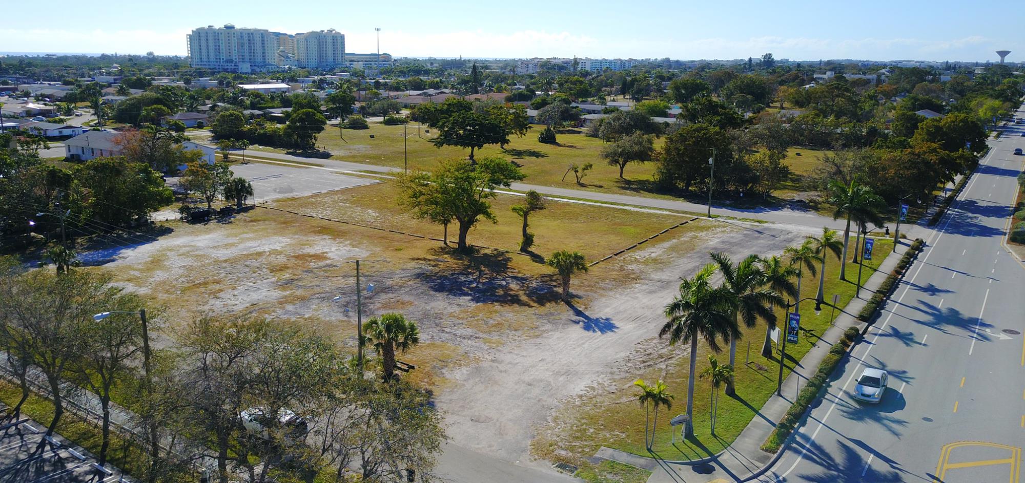 Aerial view of grass lot with trees of construction site before development began