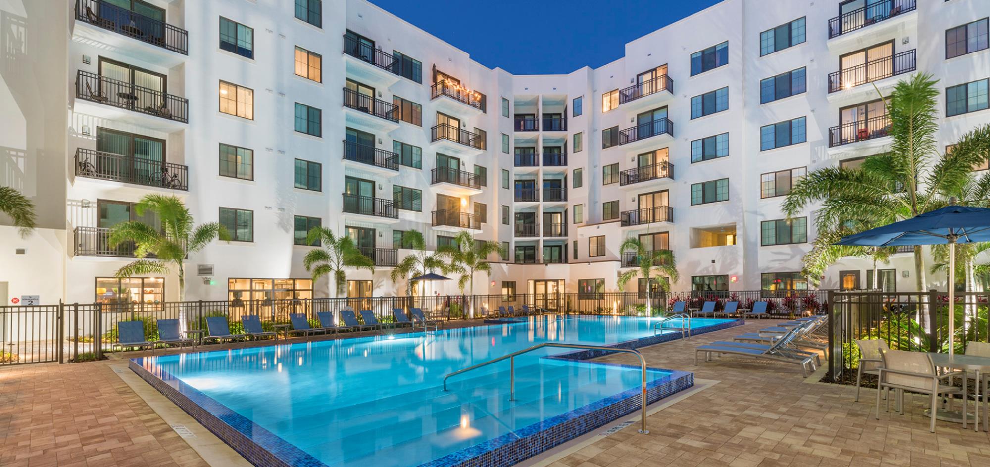 Pool with lawn furniture at 500 Ocean Apartments