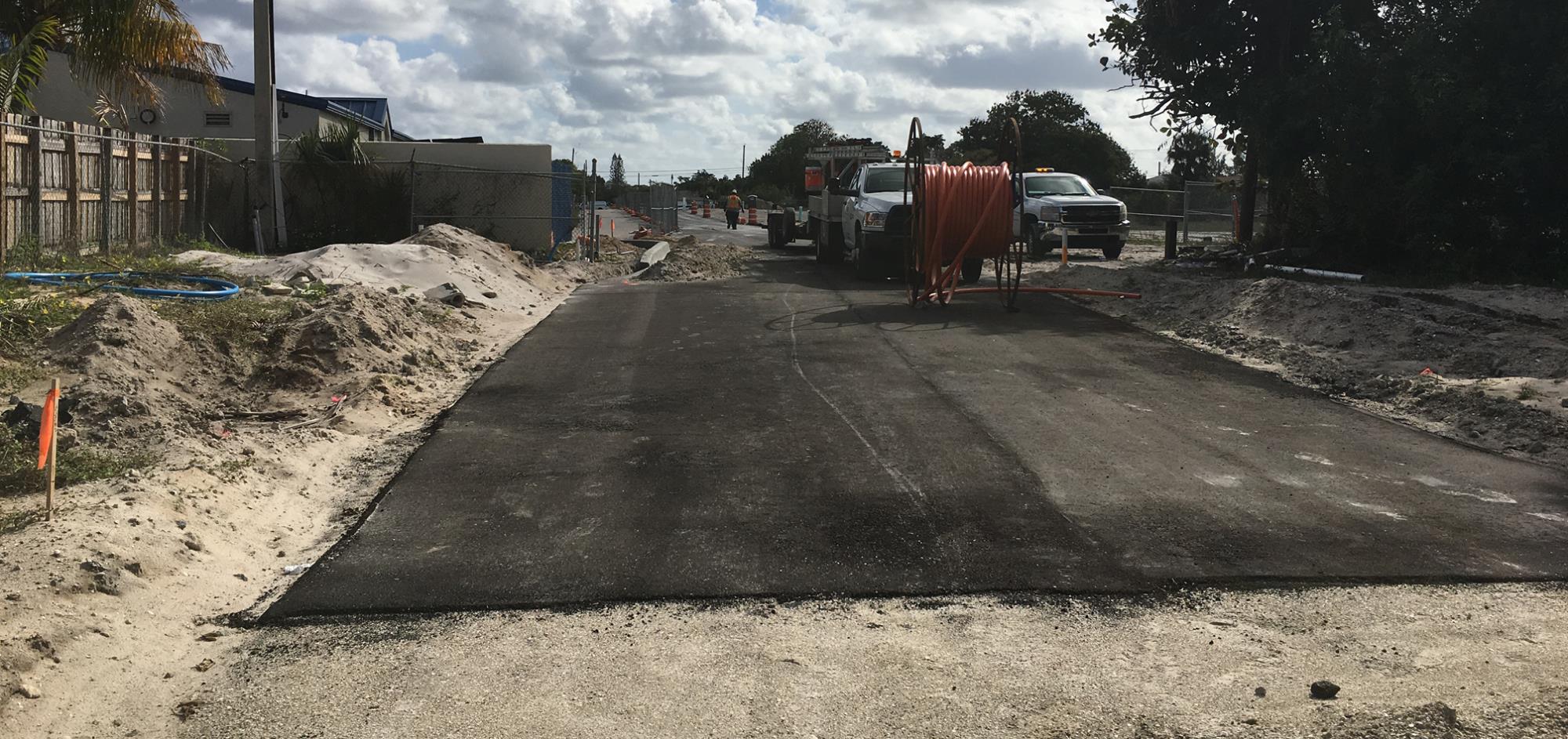 Before photo of construction in progress with partially paved and dirt road